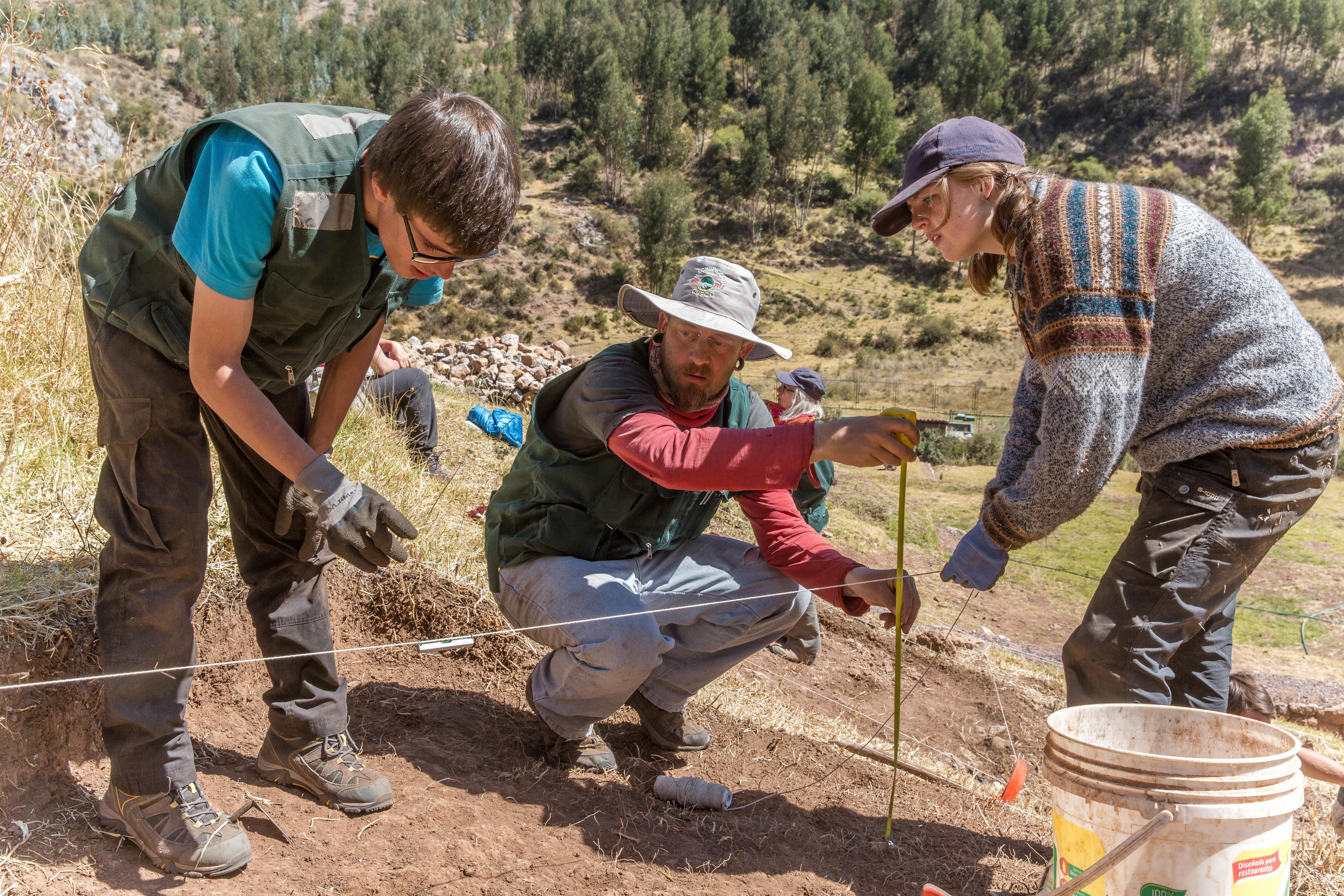 Two Projects Abroad volunteers checking the dimensions of a dig site during their archaeology volunteering in Peru. Two volunteers are pictured checking the dimensions of a dig site as part of their archaeology volunteering in Peru with Projects Abroad.